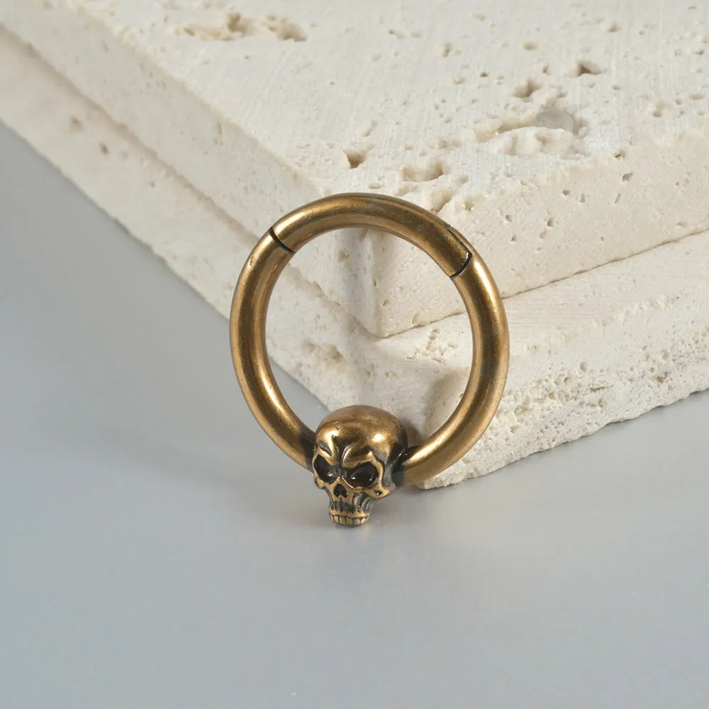 A pair of antique silver copper punk earrings featuring three small detailed ghost heads on a horizontal bar.