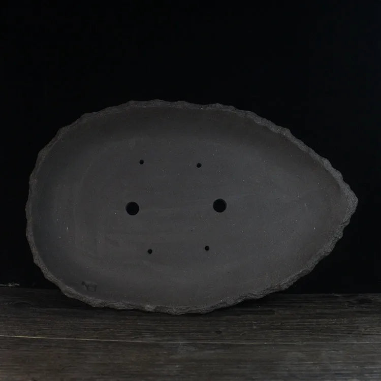 Handmade purple clay flower pot showing natural ceramic texture and floor-standing design
