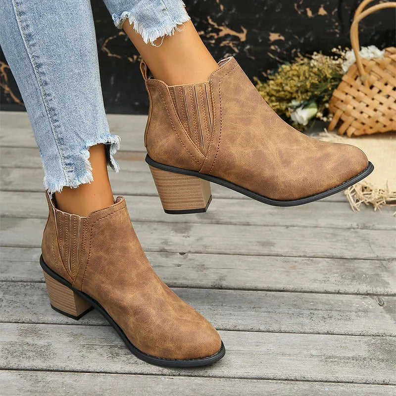 Black women's slip-on ankle boots with a pointed toe and thick square heel on a rubber sole.