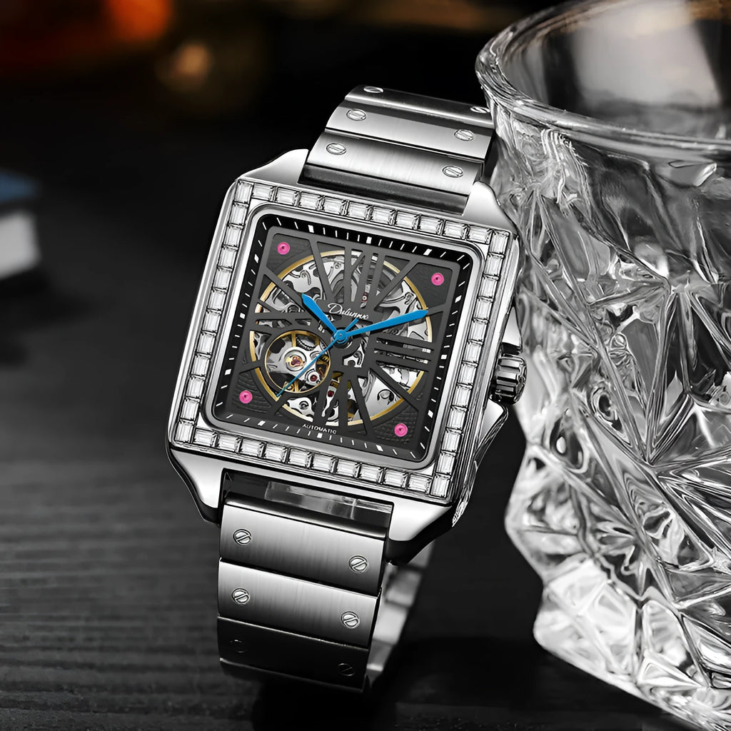 Men's square-faced automatic watch with diamond studs on a stainless steel bracelet.