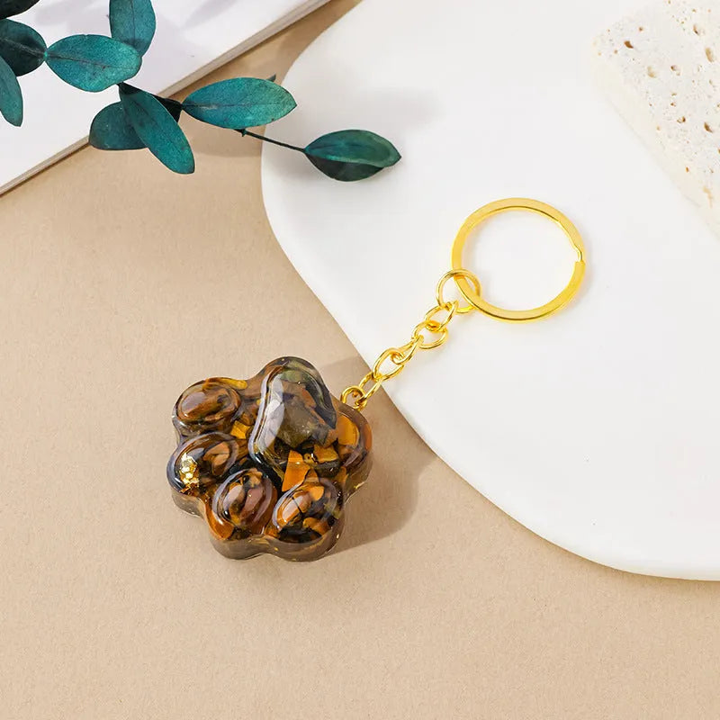 Hand-finished natural crystal cat's paw keychain pendant on a metal ring, showing detailed carving and polished stone surface.