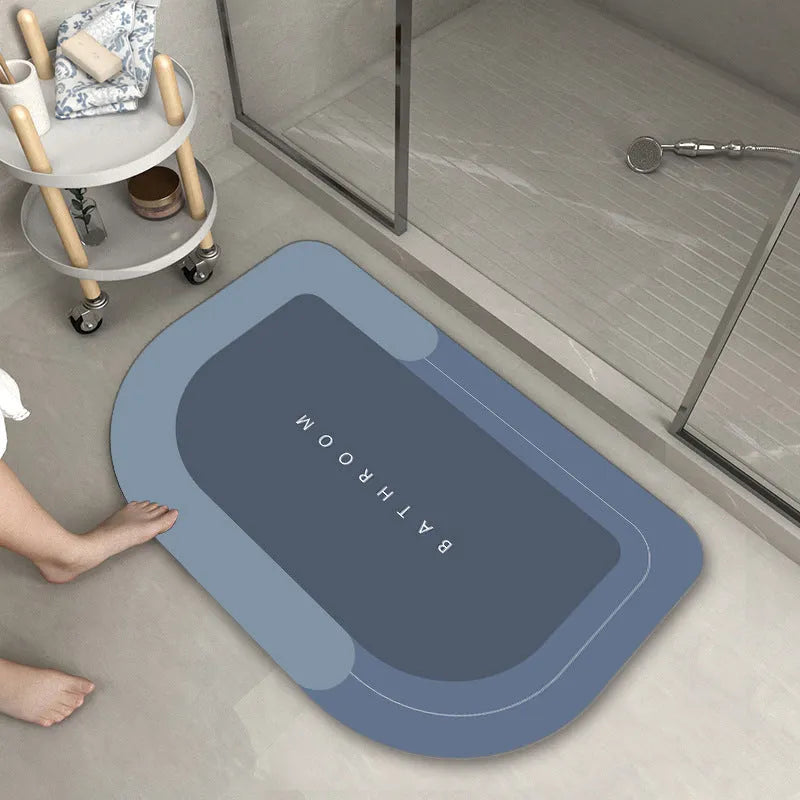 Machine-woven blended bathroom floor mat in blue, shown in an oval shape on a tiled floor.