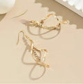 A pair of gold-coloured spiral design earrings with a geometric ellipse shape for women.