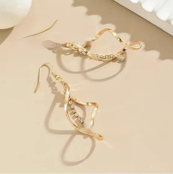 A pair of gold-coloured spiral design earrings with a geometric ellipse shape for women.