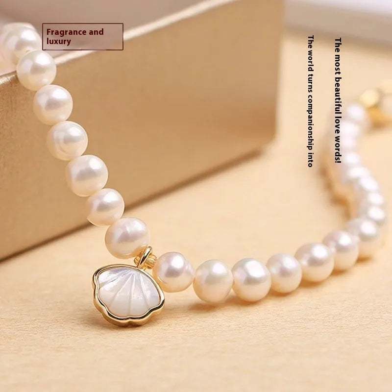 A women's freshwater pearl bracelet with a fan-shaped shell clasp, shown in both elastic and extension chain fastening styles.