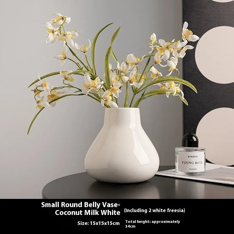 Modern ceramic vase with two white artificial orchid stems in minimalist home setting