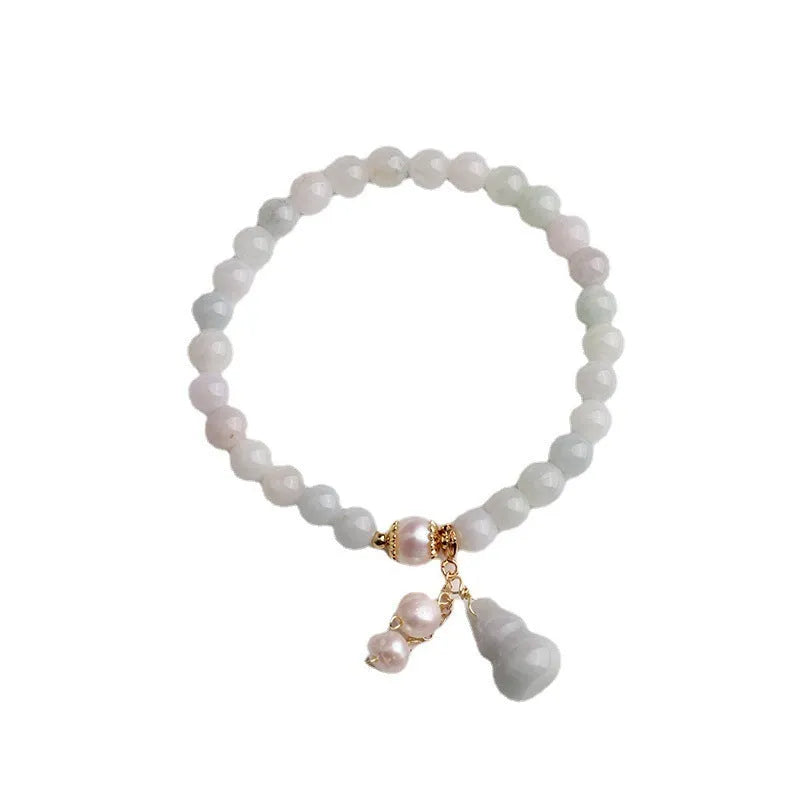 Traditional Chinese style jade bracelet with raised gourd design and pearl accents on green stone