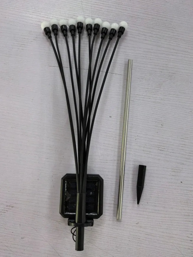 Solar-powered LED firefly garden spike light with multiple heads and a press-in ground plug on grass.