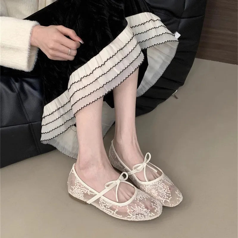Pink flat heel Mary Jane evening shoes with lace mesh upper and rubber sole.