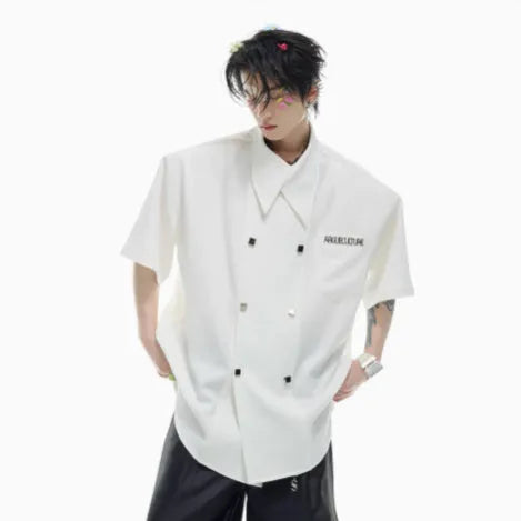 A man's loose-fitting short-sleeved casual shirt in a light colour with a lapel collar and decorative button detail.