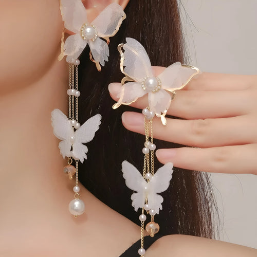 White butterfly shaped earrings with lace metalwork, a dangling tassel, pearl accents, and sparkling rhinestones.