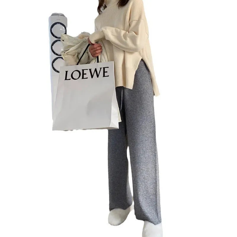 Women's high-waisted knitted wide-leg trousers in black, shown in a casual setting.