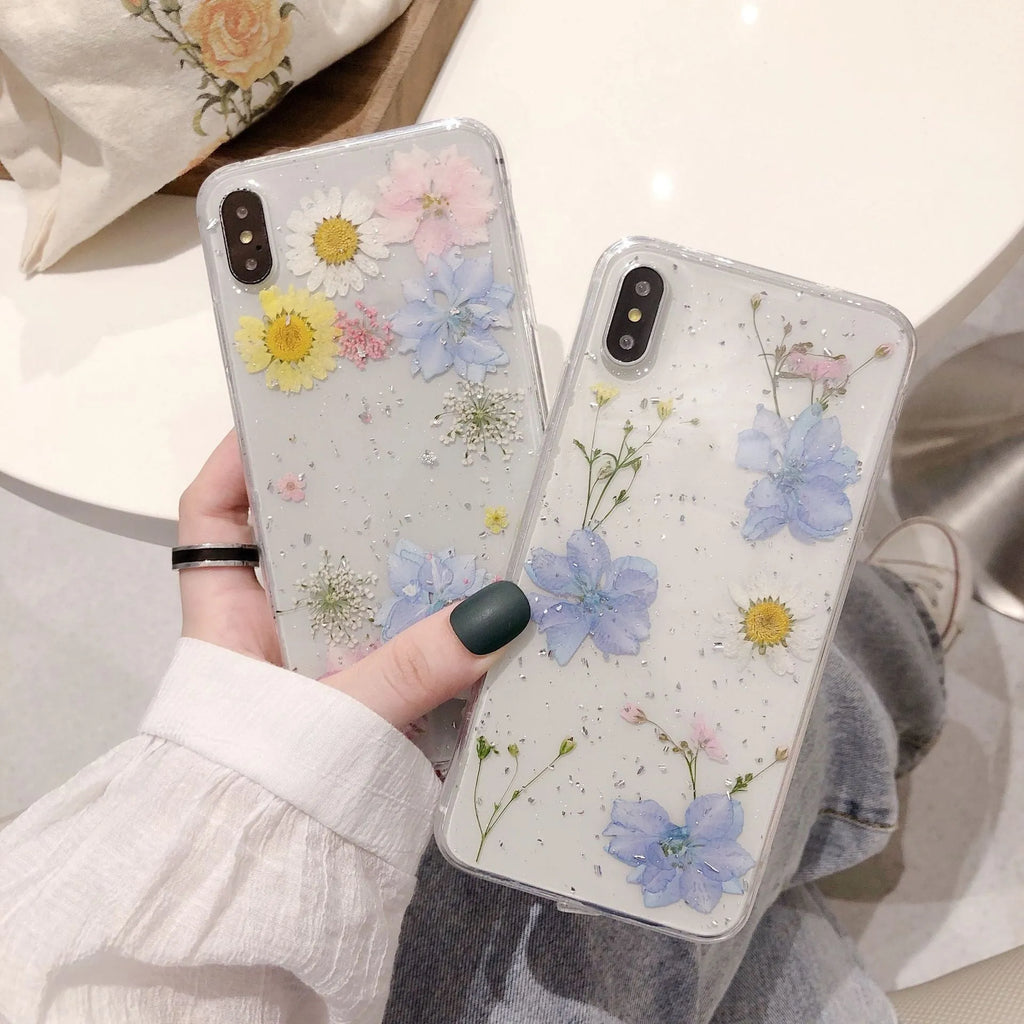 Transparent silicone phone case with real dried daisy flower and glitter design in blue and pink