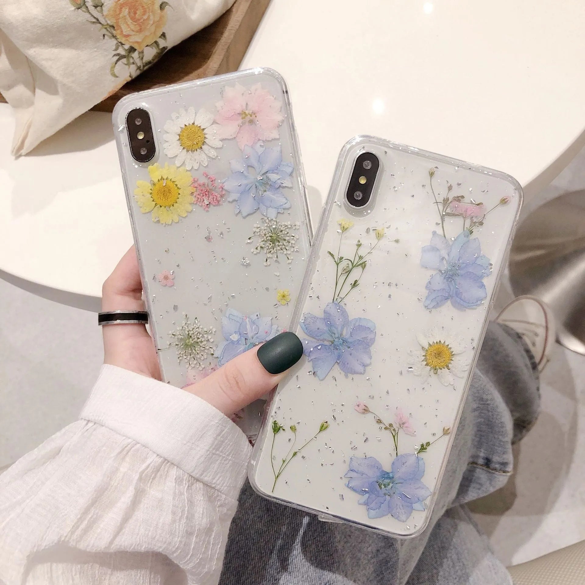Transparent silicone phone case with real dried daisy flower and glitter design in blue and pink