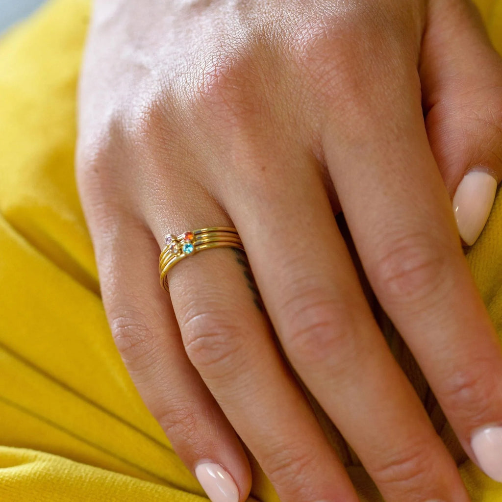 Gold-toned titanium steel engraved ring with December birthstone colour and geometric layered design.
