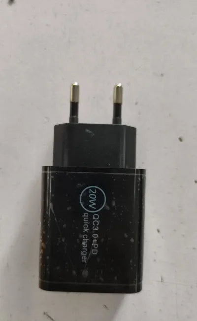Black 18W USB-C fast wall charger with US plug next to a smartphone