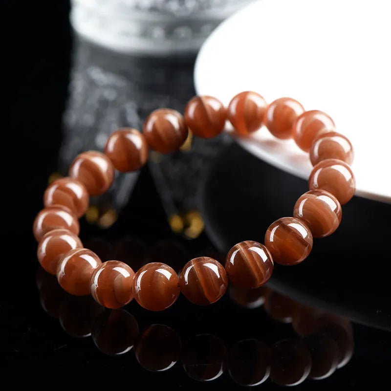 Natural Old Mine Rhodochrosite round bead bracelet with Ruyi element, shown in 6mm and 8mm sizes.