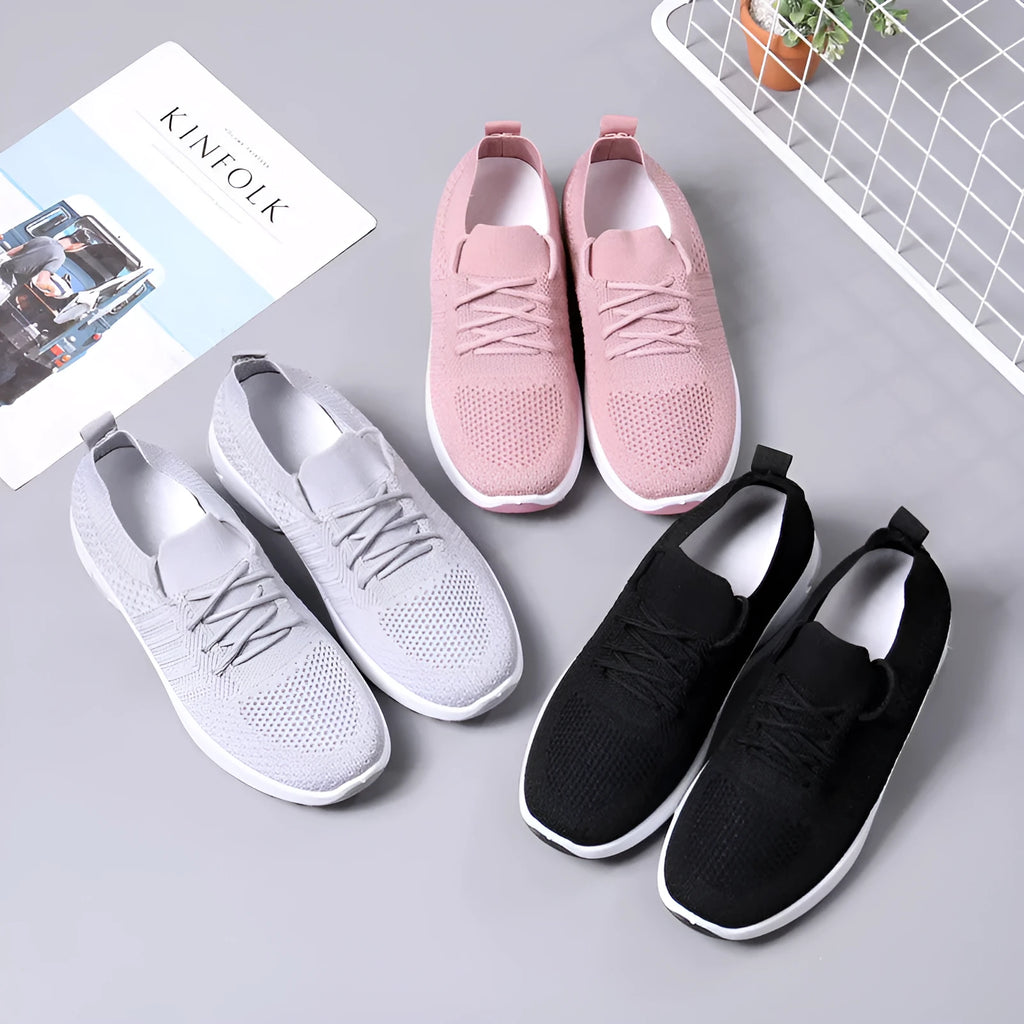 Women's solid-colour mesh sneaker with lace-up front and round toe, shown in grey.
