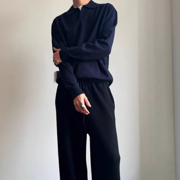 Pure wool polo sweater with lapel collar in navy blue on a hanger.