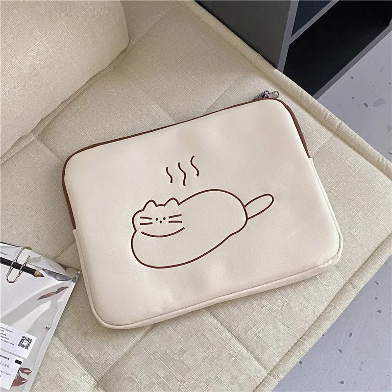 Embroidered cat design on a navy blue nylon tablet protective sleeve with a black zipper, shown next to a tablet.