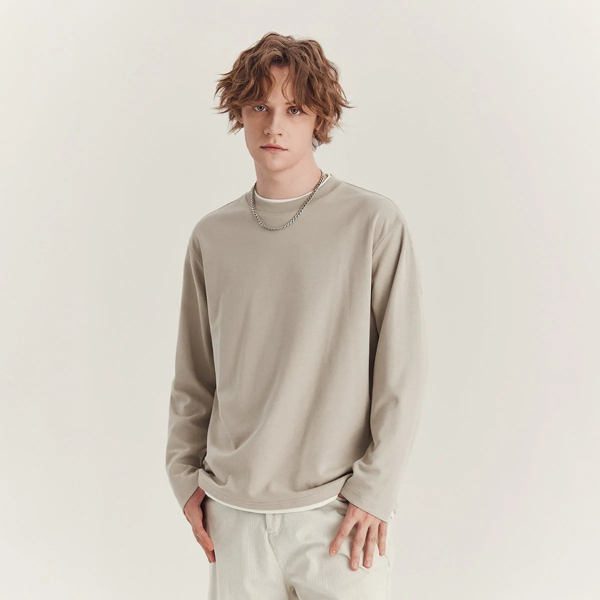 Man wearing a loose grey long-sleeved cotton blend T-shirt with a round neck.