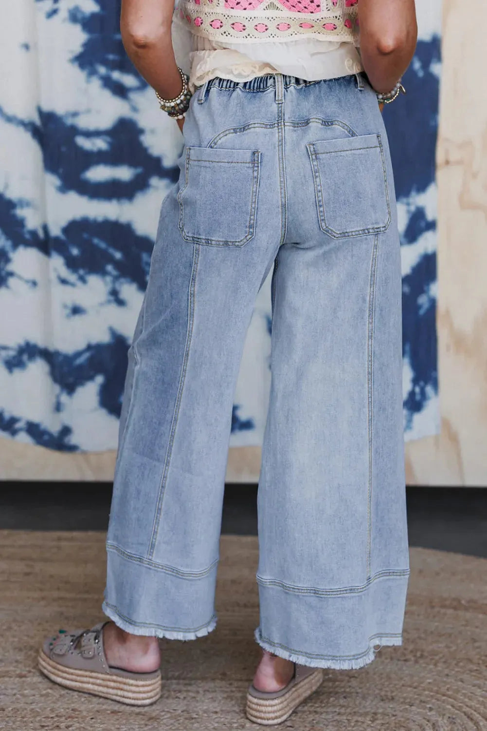 Beau blue women's wide-leg denim trousers with a drawstring waistband and raw hem detail.
