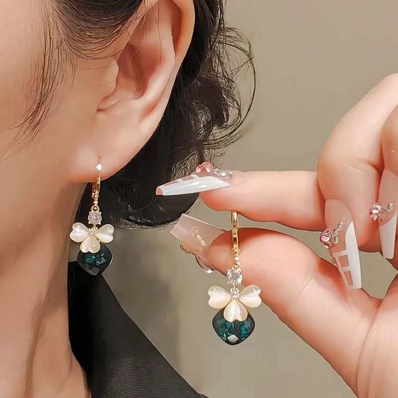 Women's blue crystal earrings with real gold plating bow shape and three-leaf flower motif