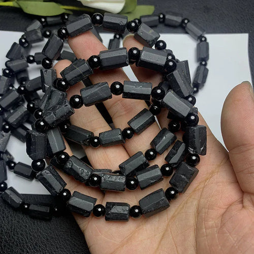 Black tourmaline rough stone bracelet on a wrist, showing natural texture and 10mm size