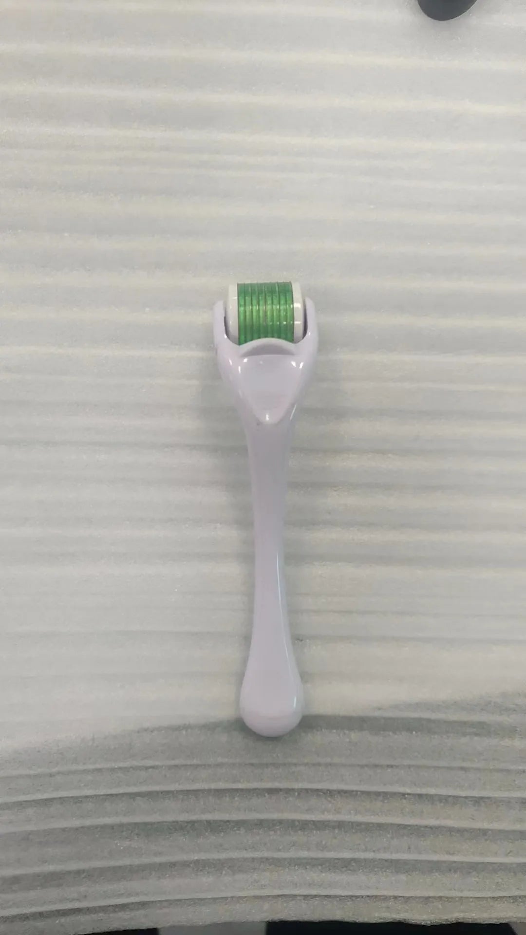 540 micro needle roller tool with black handle and coloured wheel on a white background.