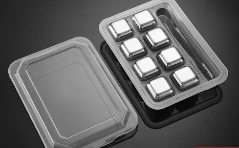Set of eight stainless steel whiskey chilling stones and metal clip in storage box.