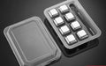 Set of eight stainless steel whiskey chilling stones and metal clip in storage box.