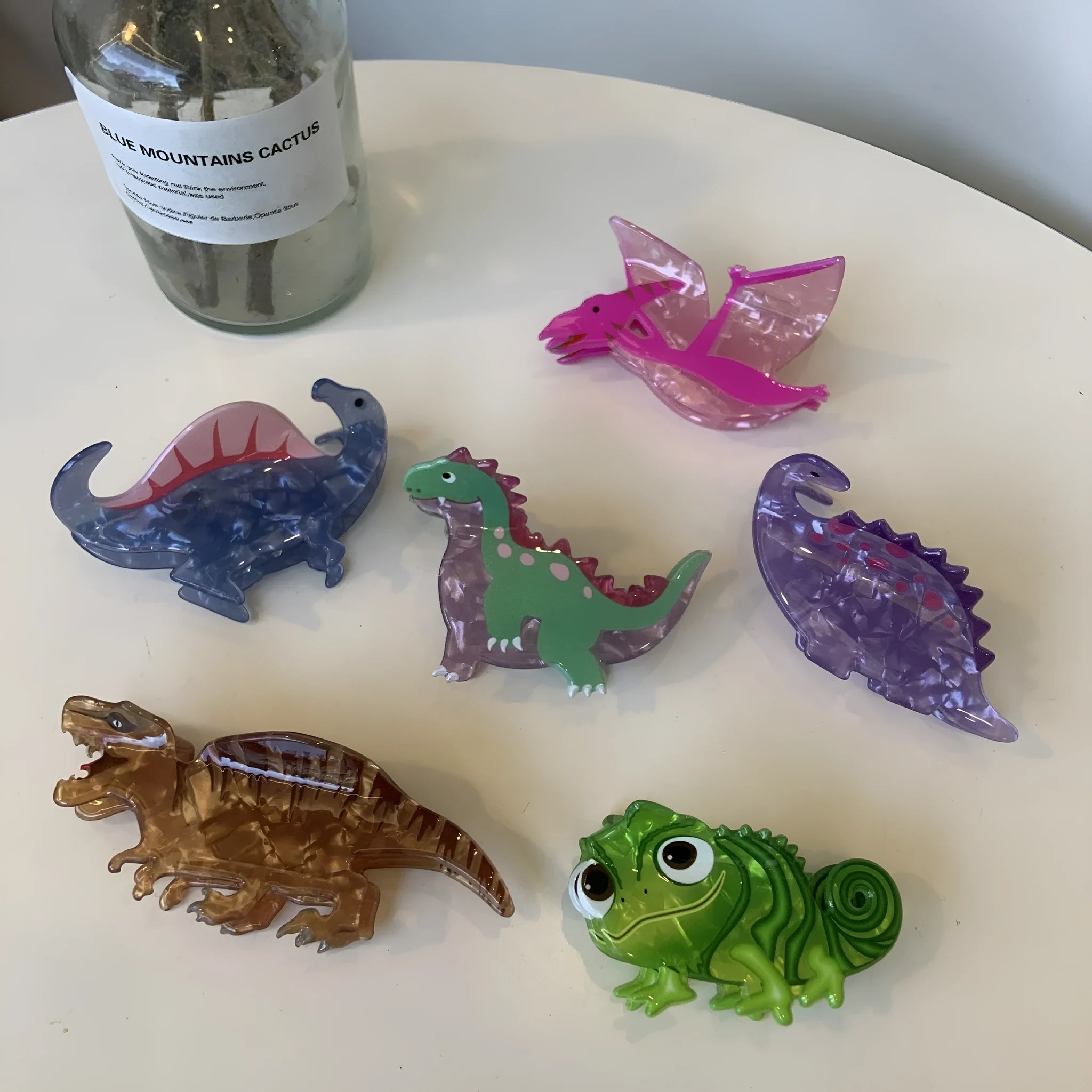 Dinosaur acrylic jaw hair grip clip showing colourful little dinosaur designs on clear background