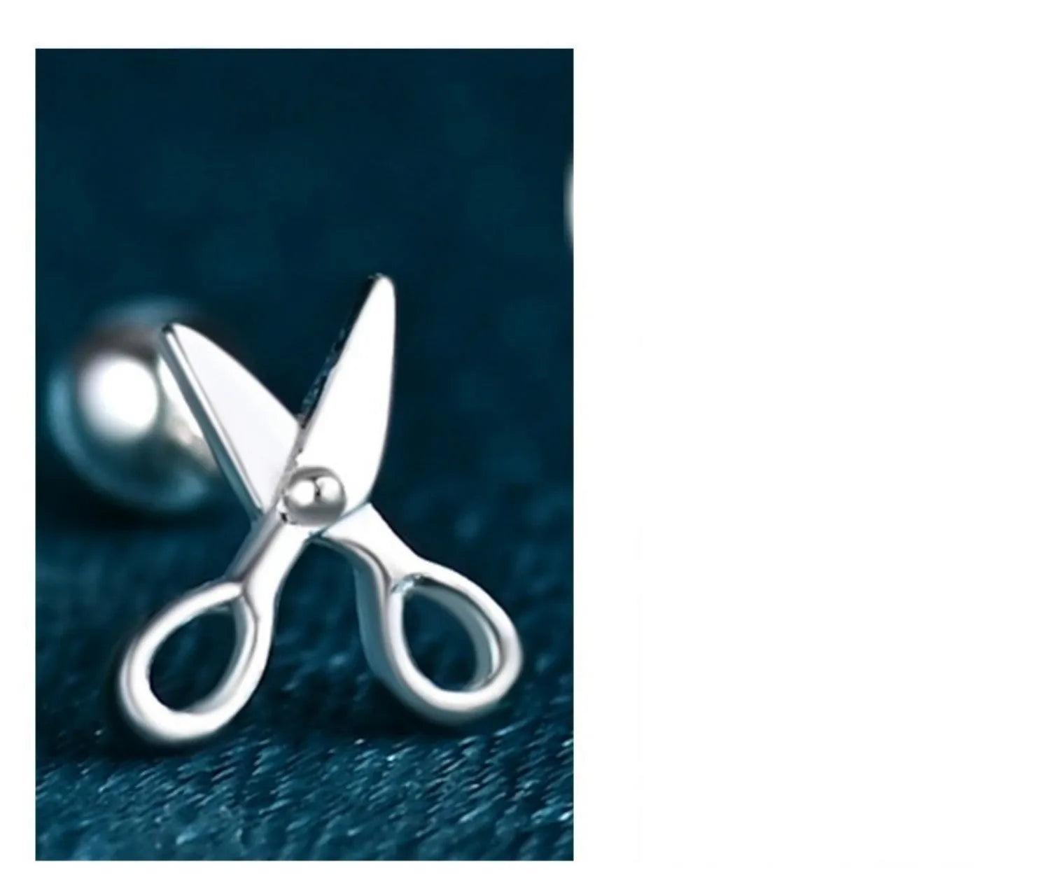 A pair of screw-back earrings made from 999 pure silver with a miniature silver scissors charm.