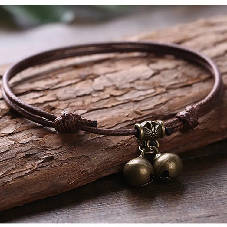 A nylon rope dog collar with a brass buckle shown alongside a version with a brass bell, in black, red, and coffee colours.