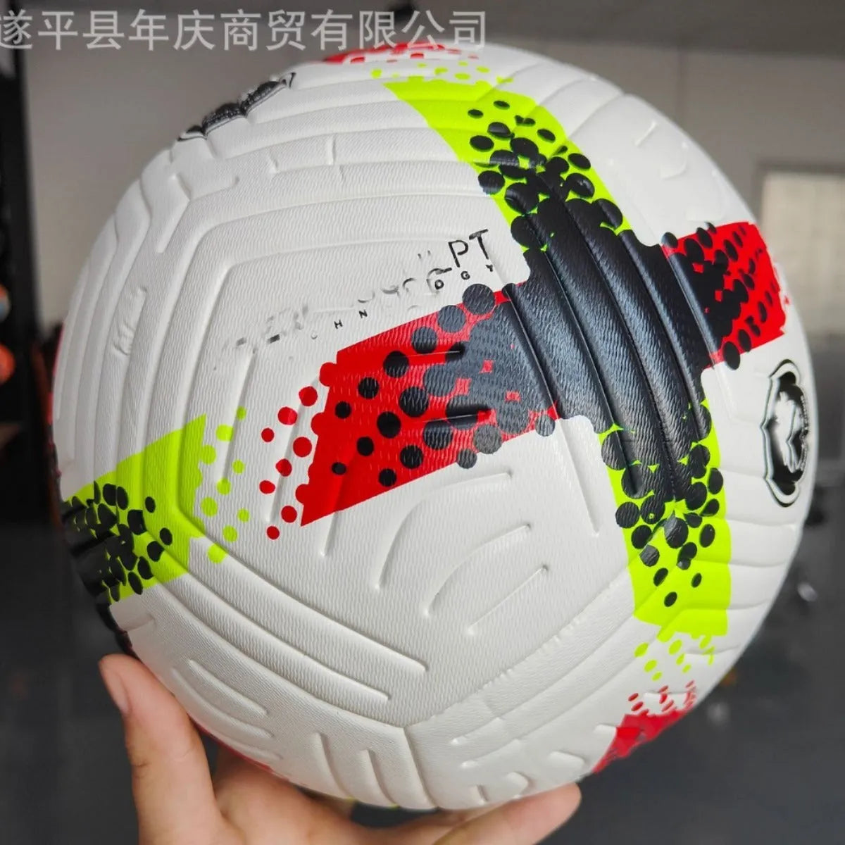 Fluorescent green Size 5 football on a field, showing seamless PU construction.