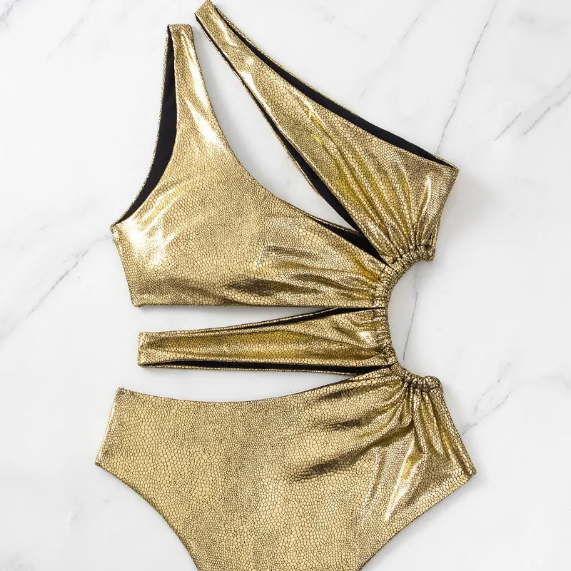 Gold women's one-piece swimsuit with a backless design on a mannequin.