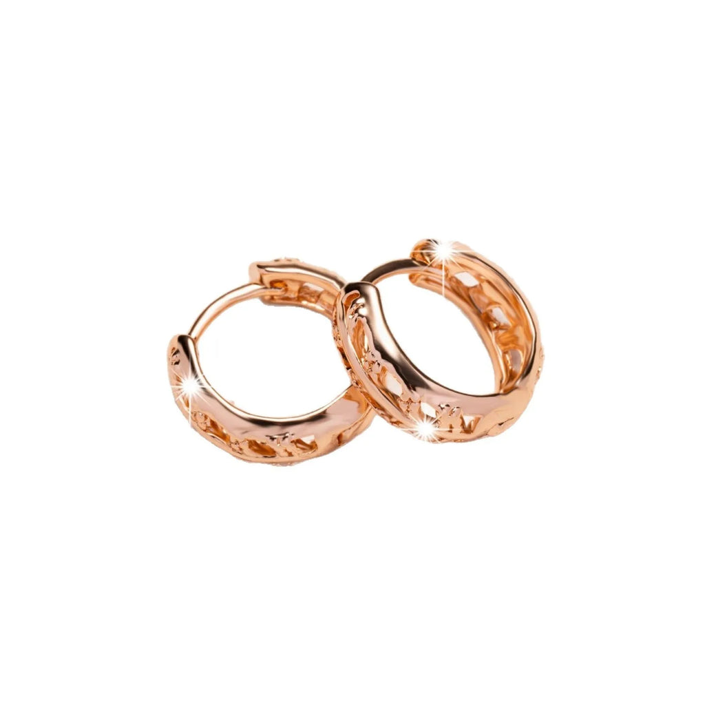 Small copper earrings with hollowed-out heart and leaf design in rose gold colour.