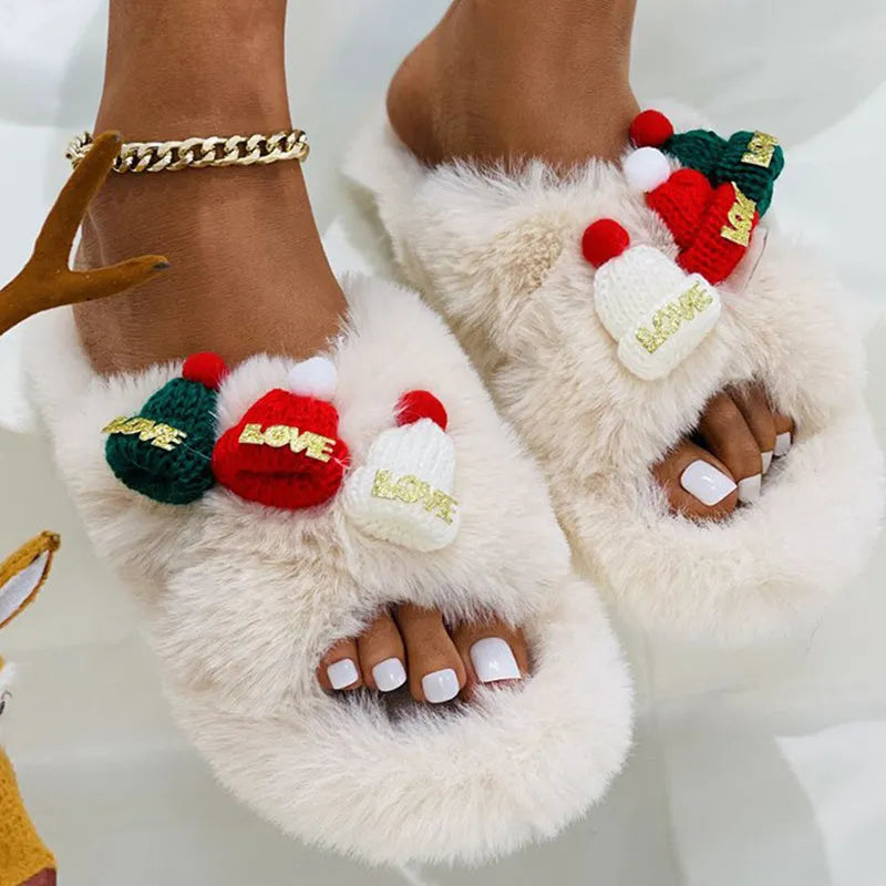 Women's festive slippers with a Christmas hat decoration on a faux plush upper.