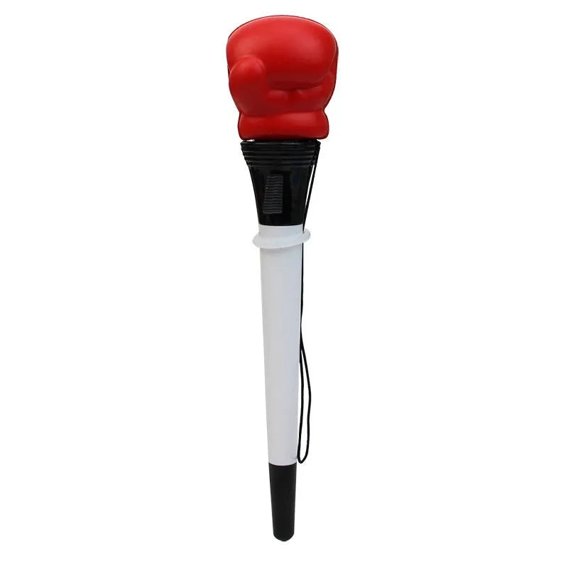 Boxing pressure pen ejection press stationery toy with four black pens on a desk.