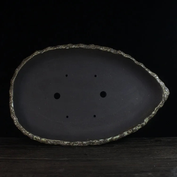 Handmade purple clay flower pot showing natural ceramic texture and floor-standing design