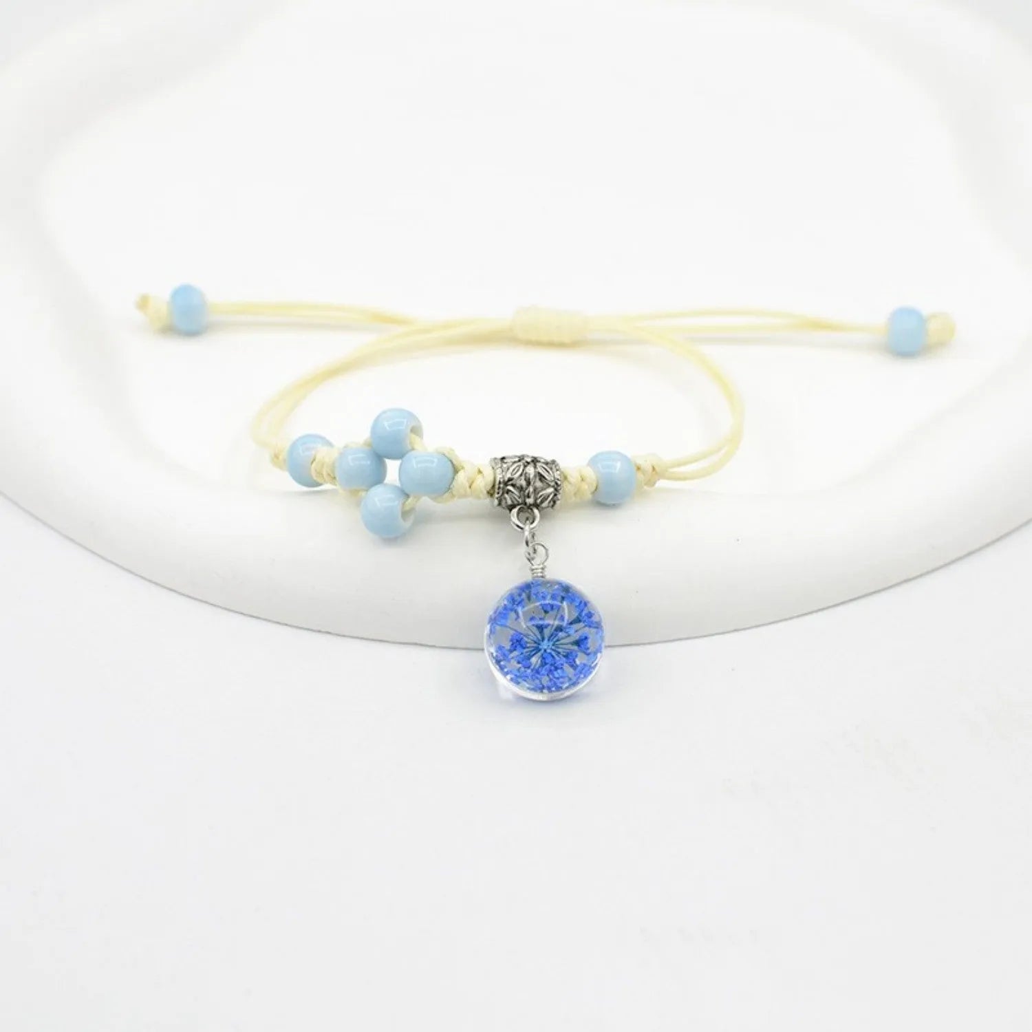 Hand-woven glass bracelet with large beads containing real dried flowers, shown in multiple colour options.