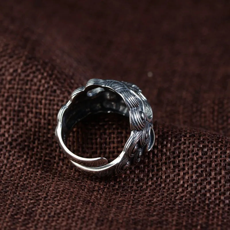 Silver open-ended ring with a raised Domineering Jibeast animal zodiac pattern.