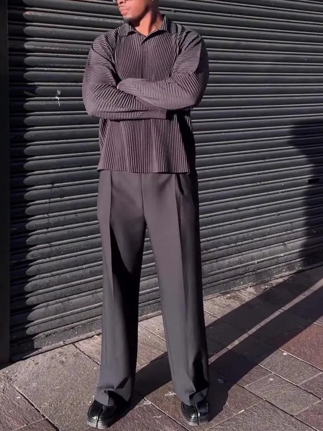 Man wearing a black pleated long-sleeved casual polyester top.