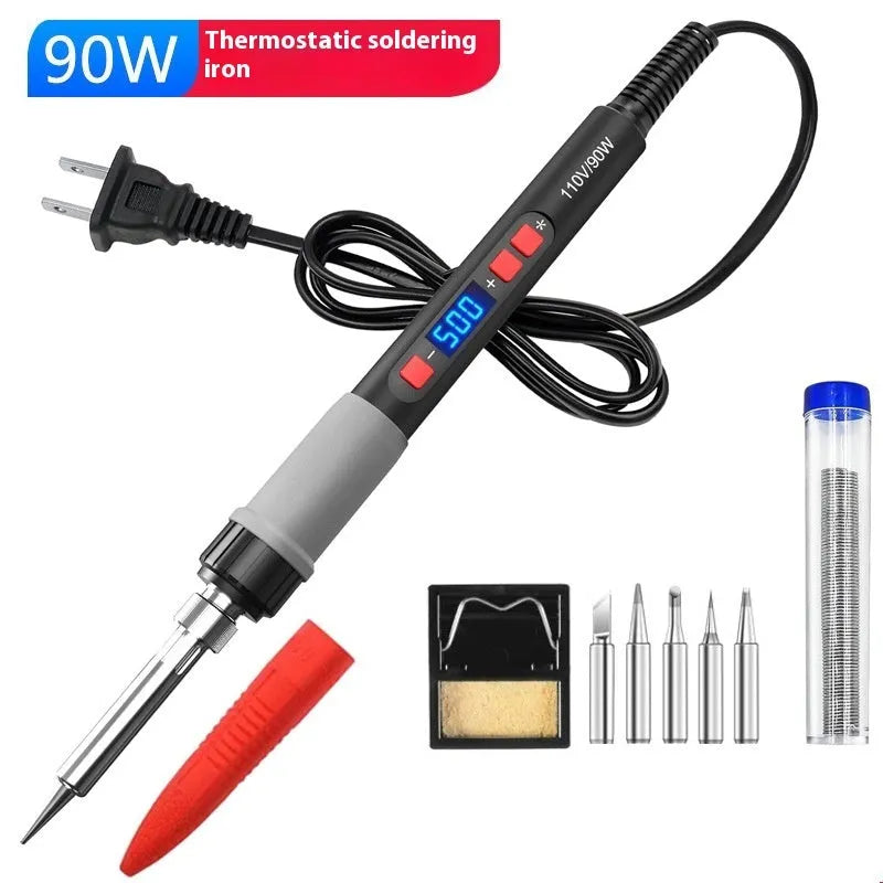 Grey 90W electric soldering iron kit with ceramic heating core, five tips, tin wire, and holder on a workbench.