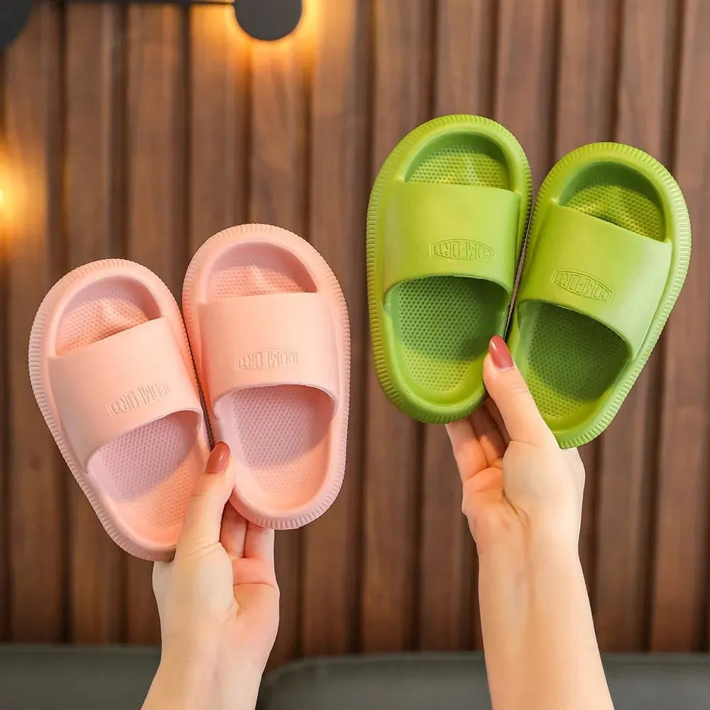 Colourful children's EVA slippers with textured sole, shown in blue, green, orange, pink, and yellow.