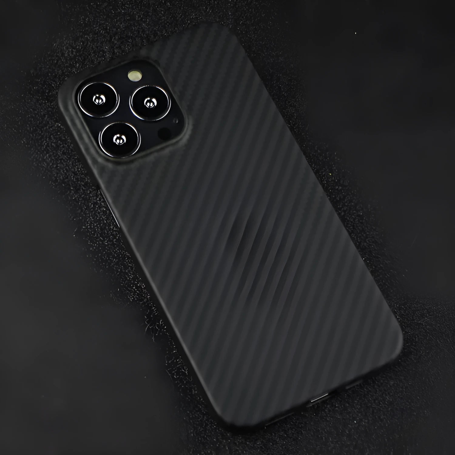 Dull black Kevlar fibre back cover case for Apple iPhone with MagSafe ring visible.