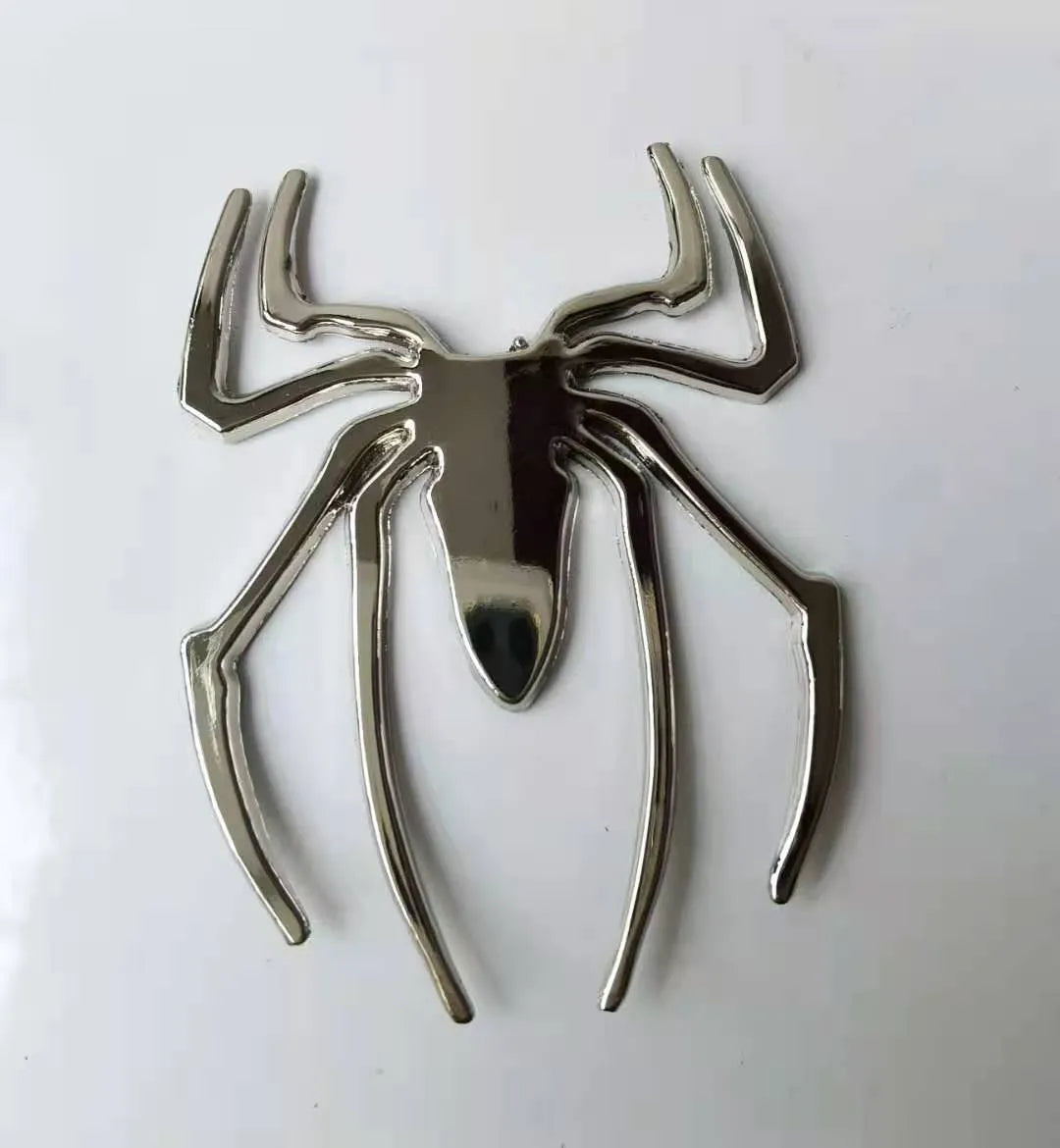 Three-dimensional metal spider car bumper sticker in gold, silver, black, and red colour options.