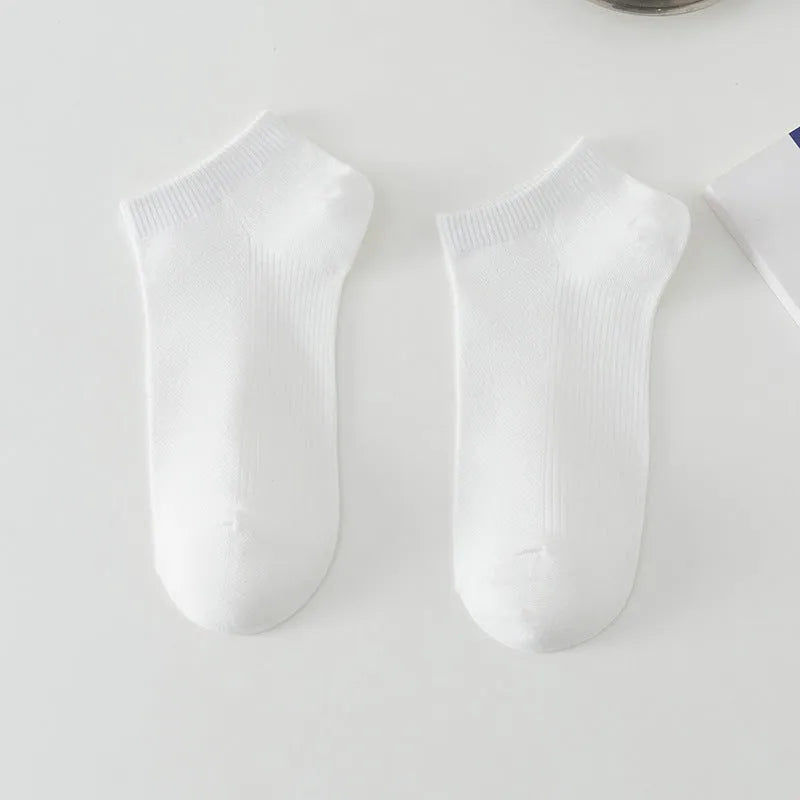 A pair of solid colour low-cut men's boat socks made from breathable polyester fabric.