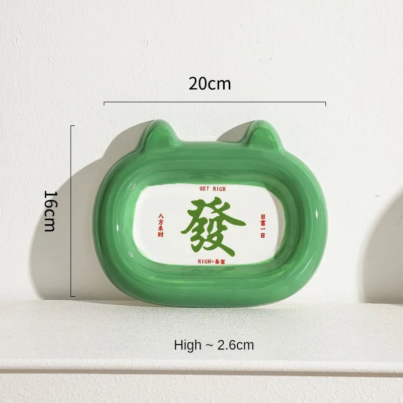 Glazed ceramic pet food bowl with animal design and non-slip rubber base ring.