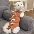 Pink lace-up cat recovery bodysuit on a table, showing back ties and full-body design for post-surgery care.